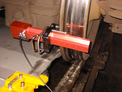 Portable measurement instrument positioned against a railway wheel